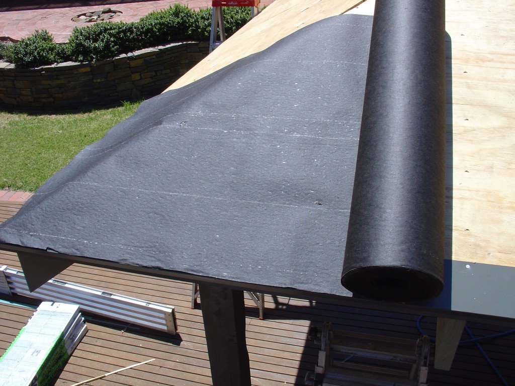 Asphalt saturated felt paper underlay rolled out covering plywood base